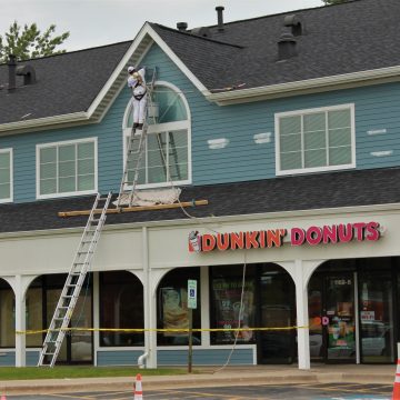 Man on ladder renovating building