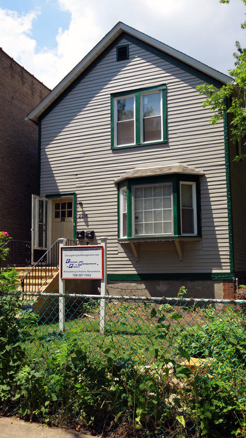 Walt Disney birthplace home before restoration showing gray aluminum siding and green trim that concealed the original 1893 wood clapboard in Chicago's Hermosa neighborhood